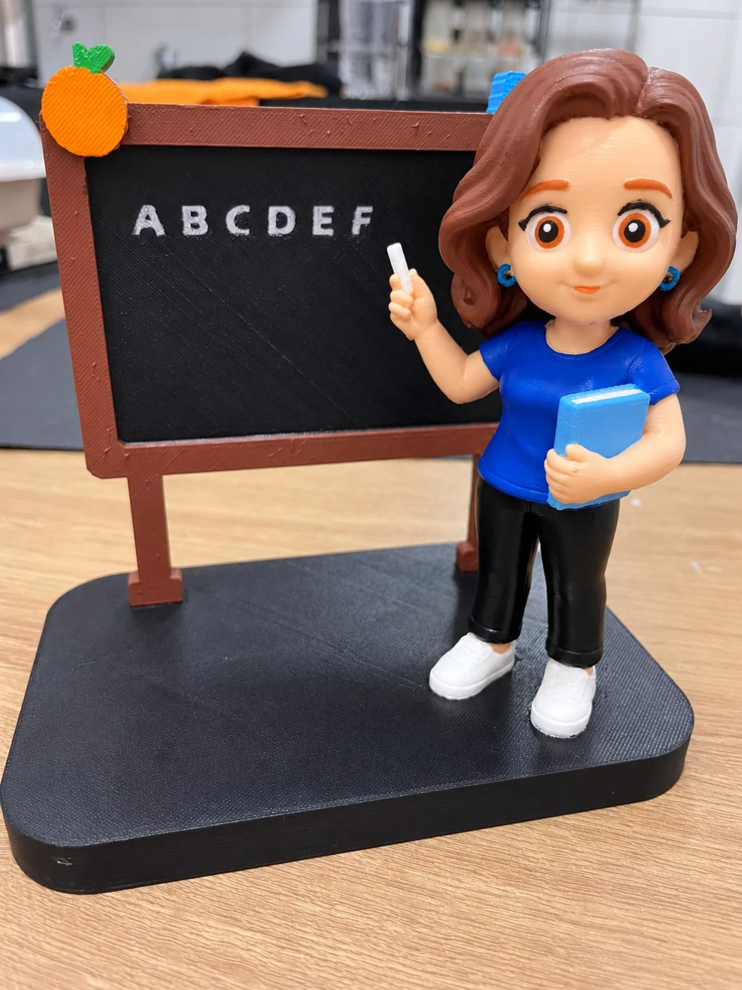 Boneca de professora com quadro e livro